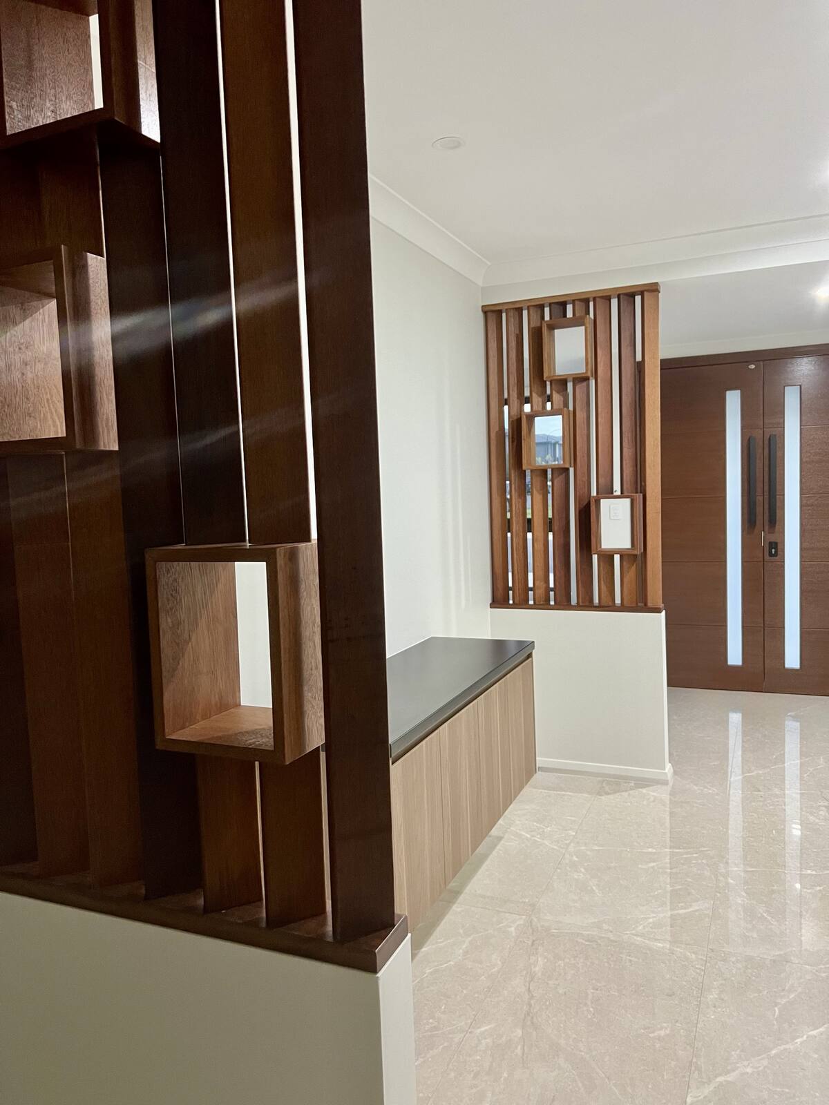 Dark timber slat feature wall and joinery at a building entry