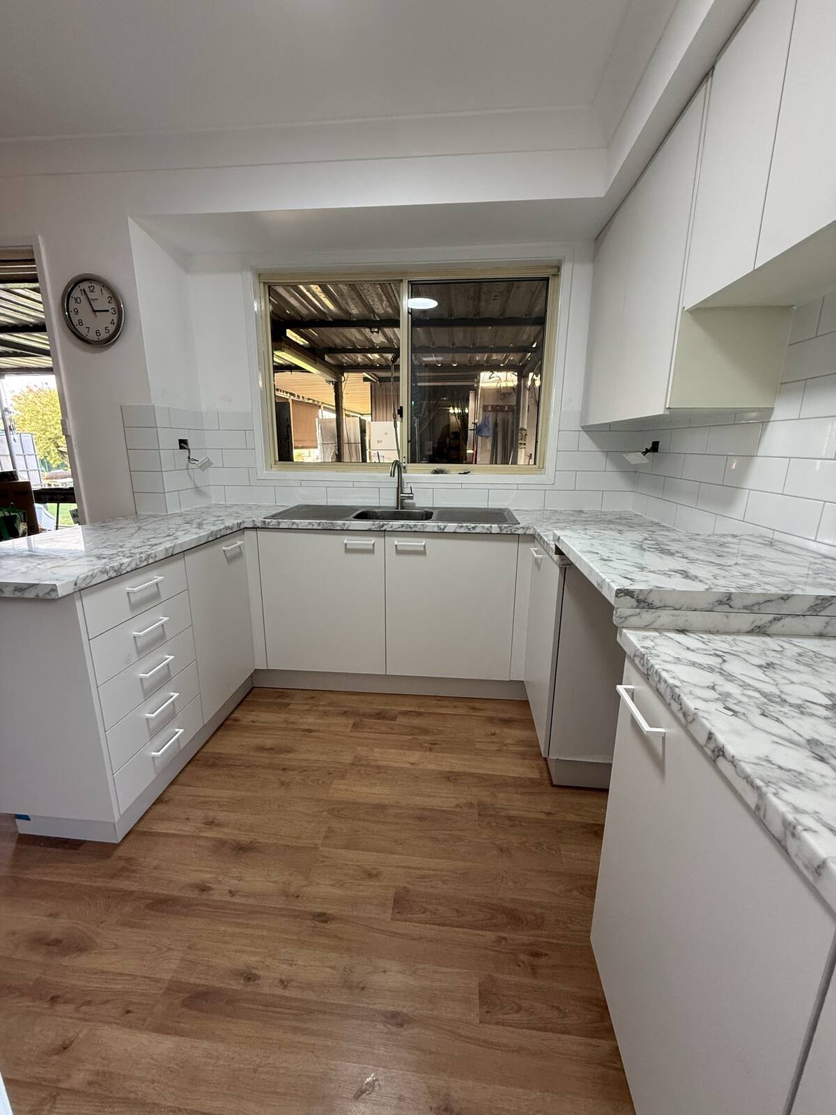 White stone-look kitchen renovation with subway tile splashback